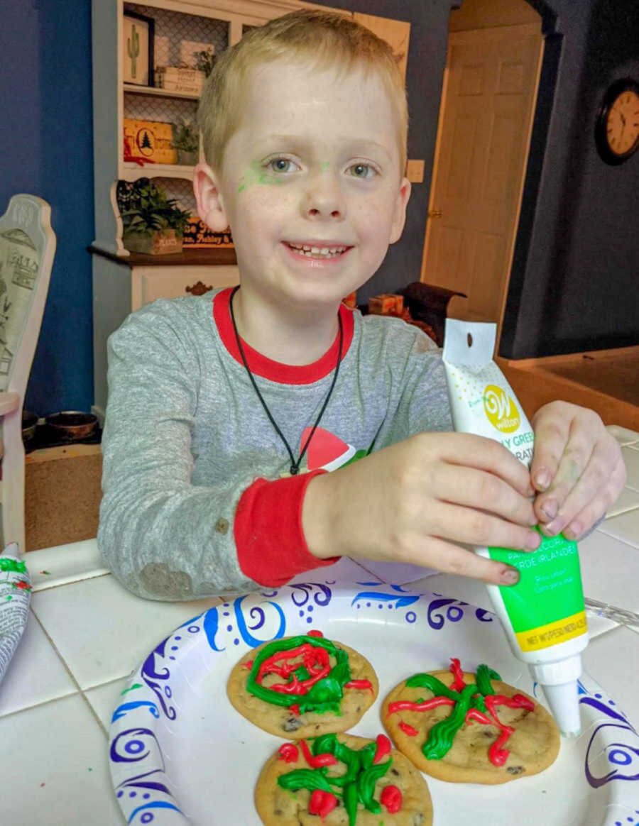 Blonde boy in Christmas pajamas making cookies