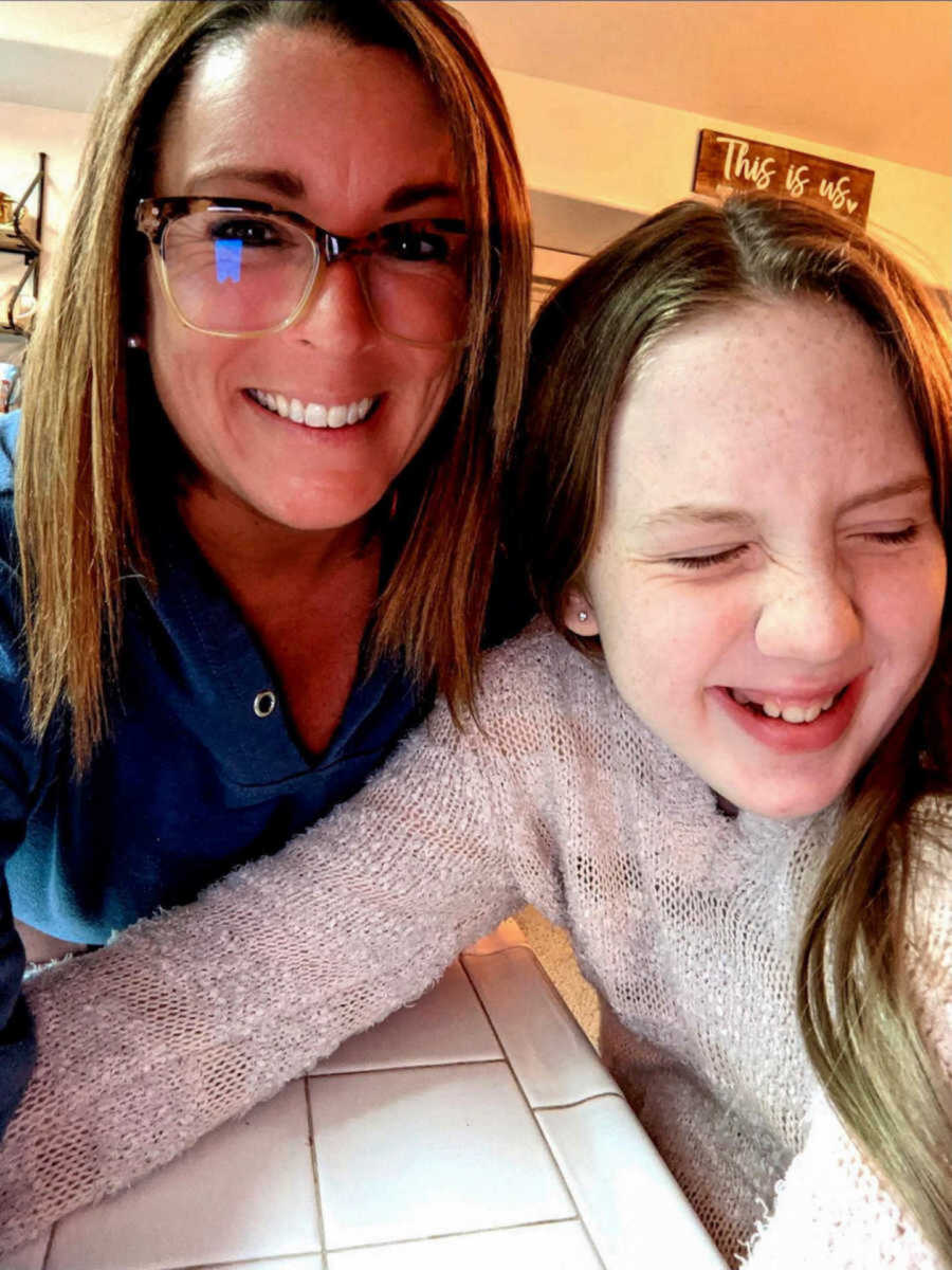 Stepmom in glasses smiling with laughing stepdaughter