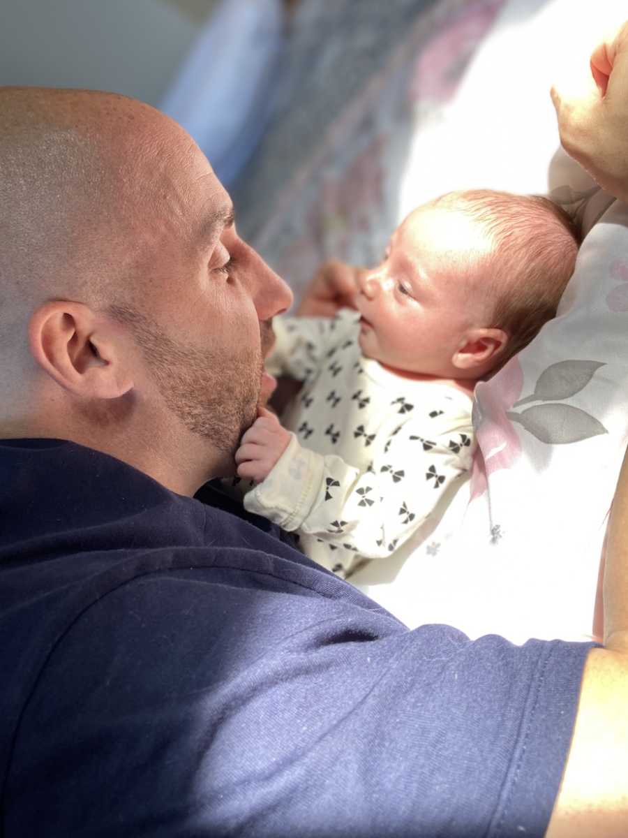 Dad lays on floor and admires baby girl.