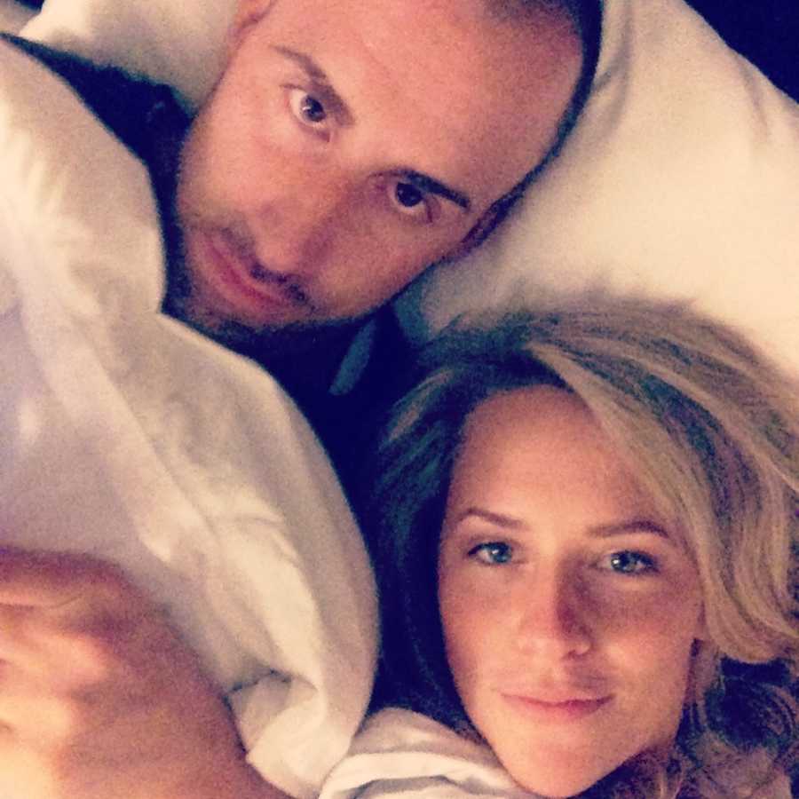 husband and wife take selfie together in bed