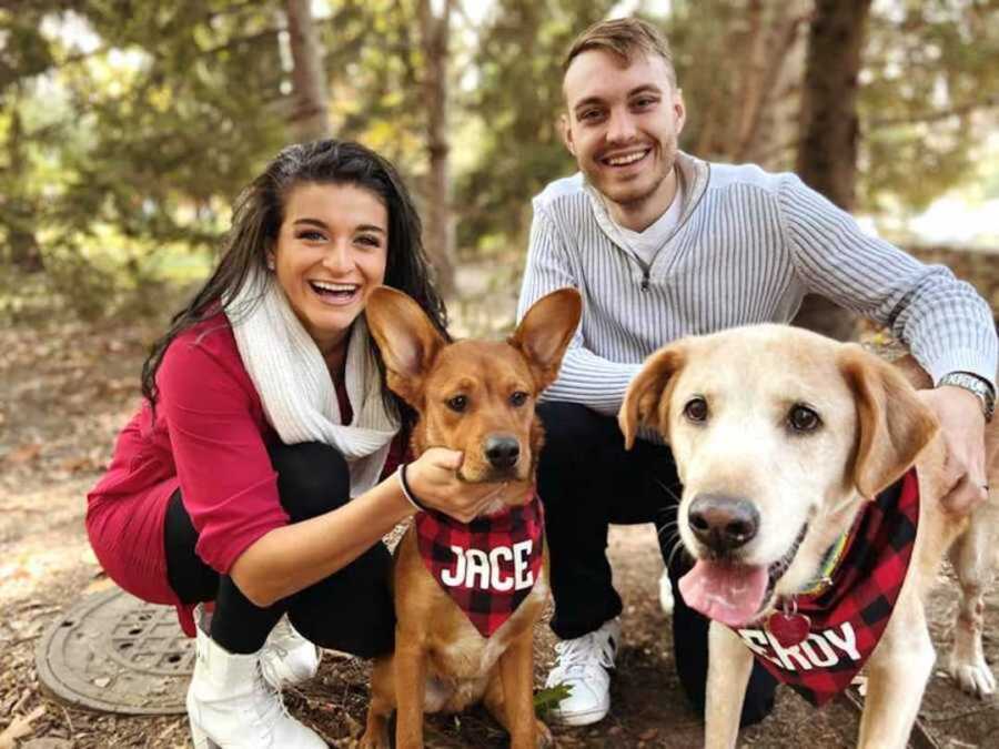 couple poses with two dogs