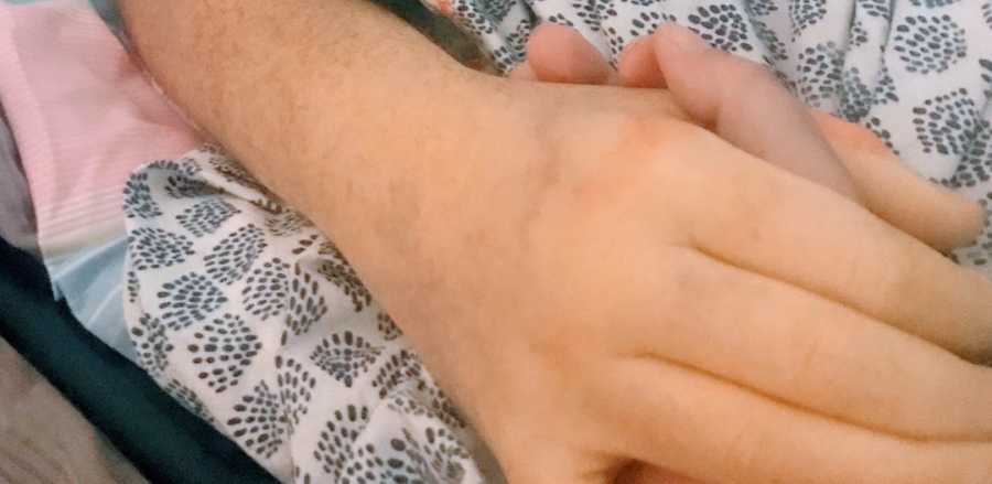 wife holds husband's hand as he passes away from colon cancer