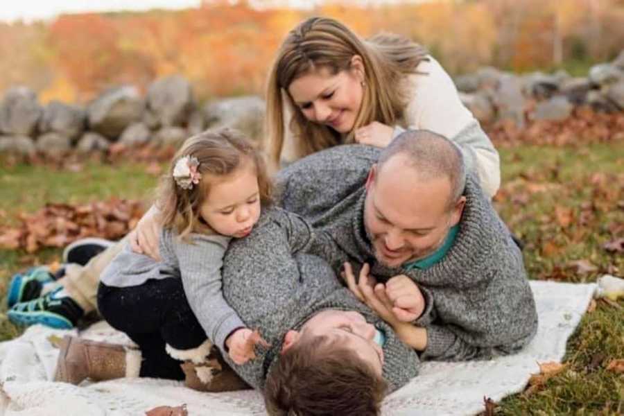 Special needs family embrace on blanket during autumn
