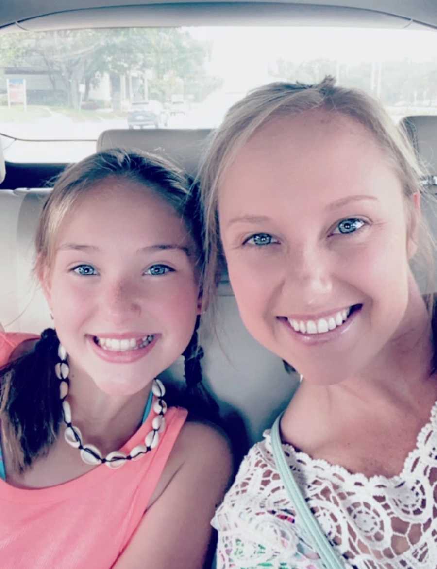 Mom and daughter smile for selfie in car seats