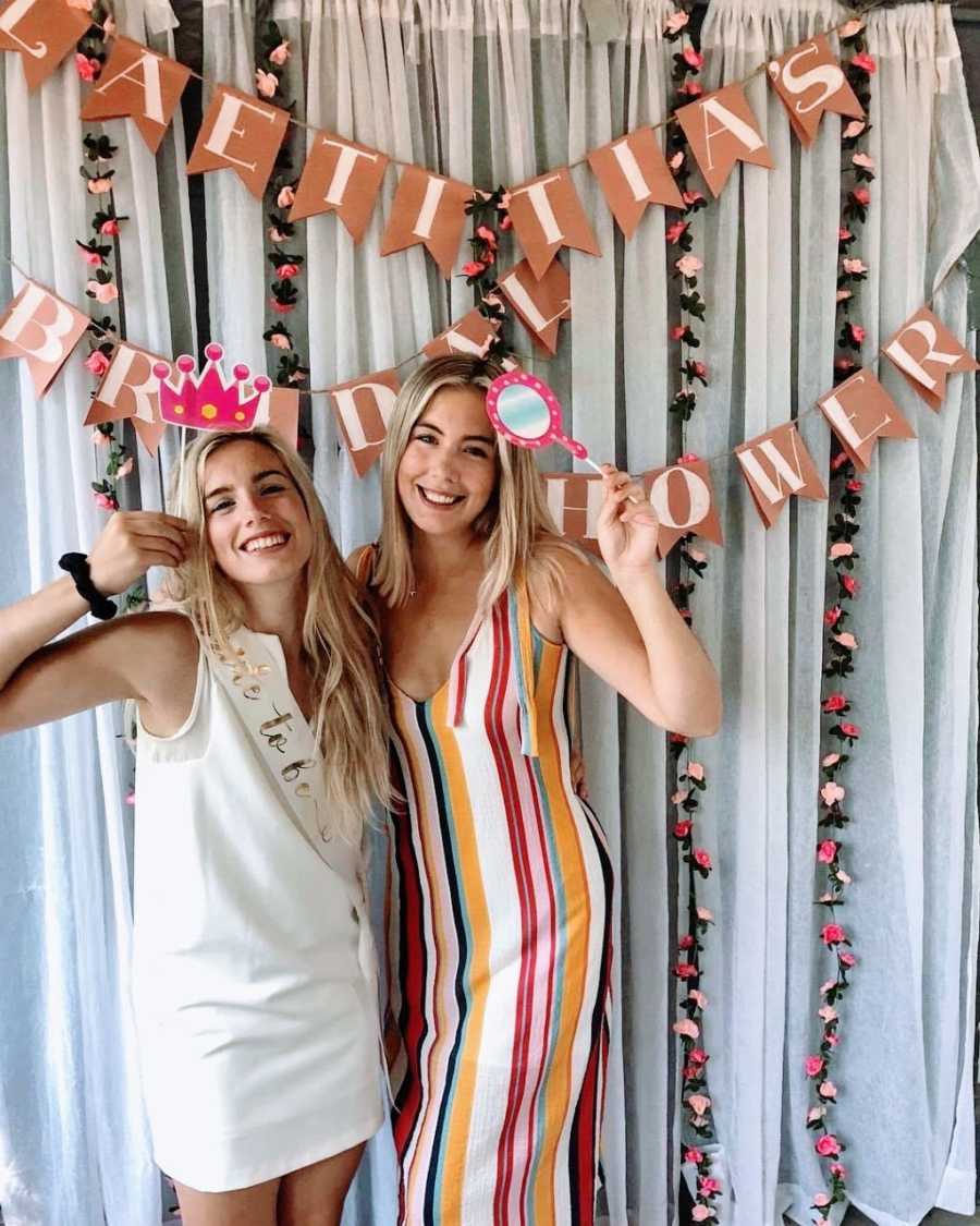 Teen mom in white dress embraces friend at bridal shower