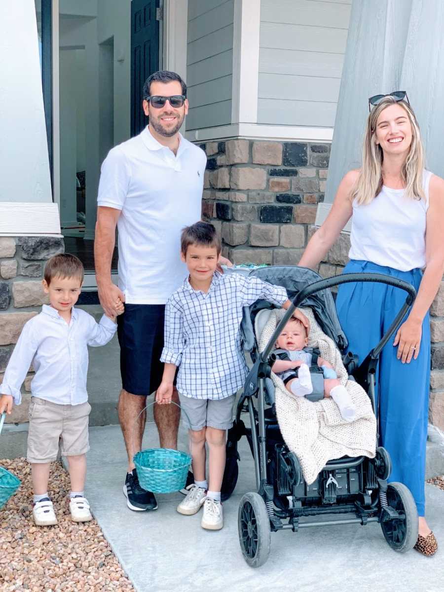 Teen mom in blue pants holds son in stroller