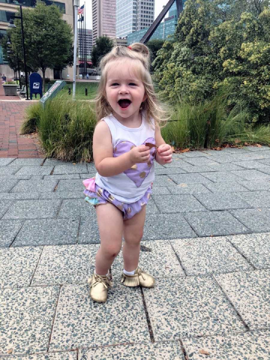 happy toddler girl standing outside