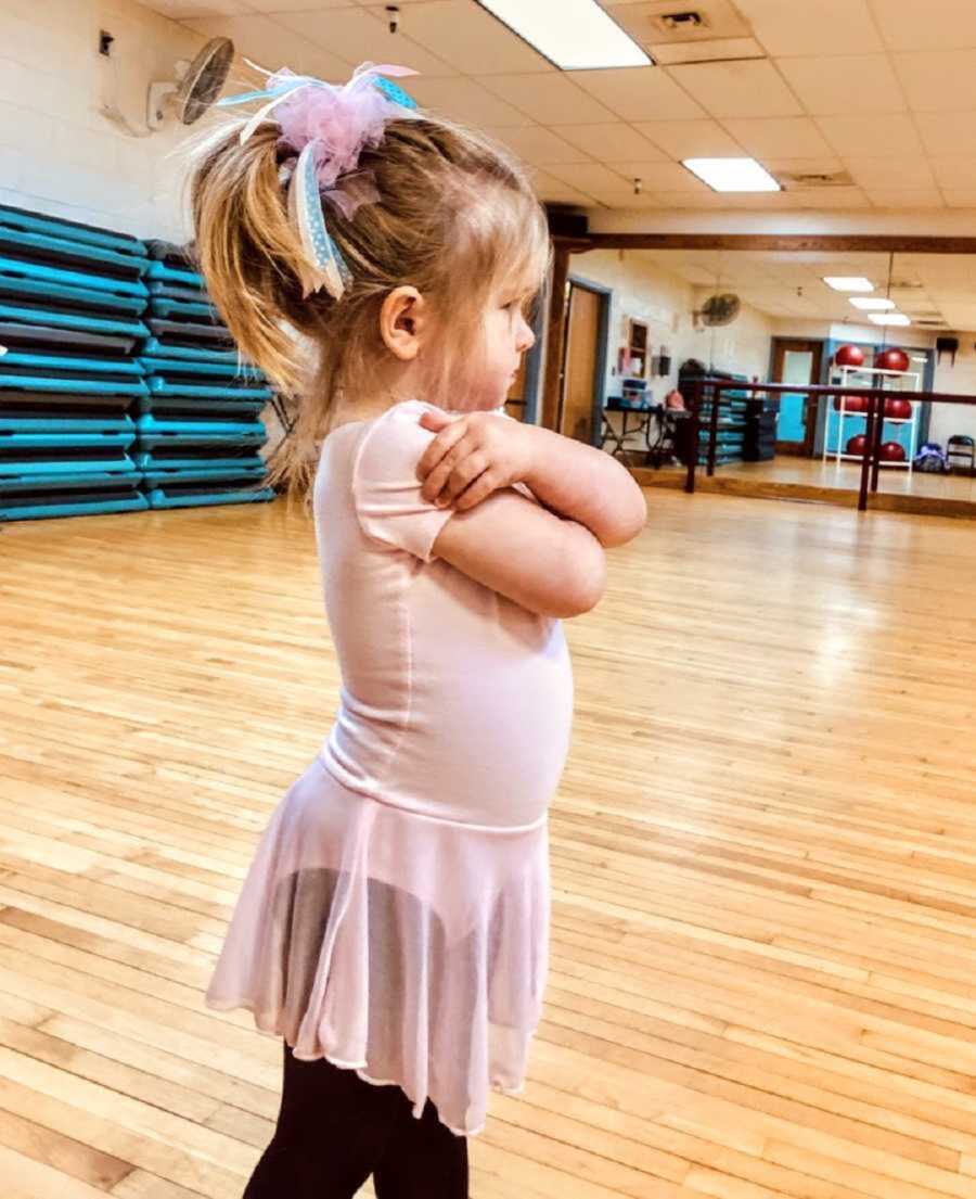 little girl dressed as ballerina stubbornly crosses arms