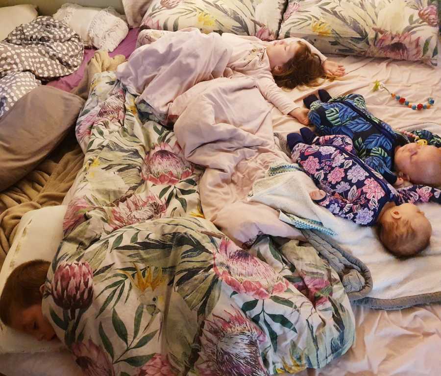 children all sleeping together on a mattress