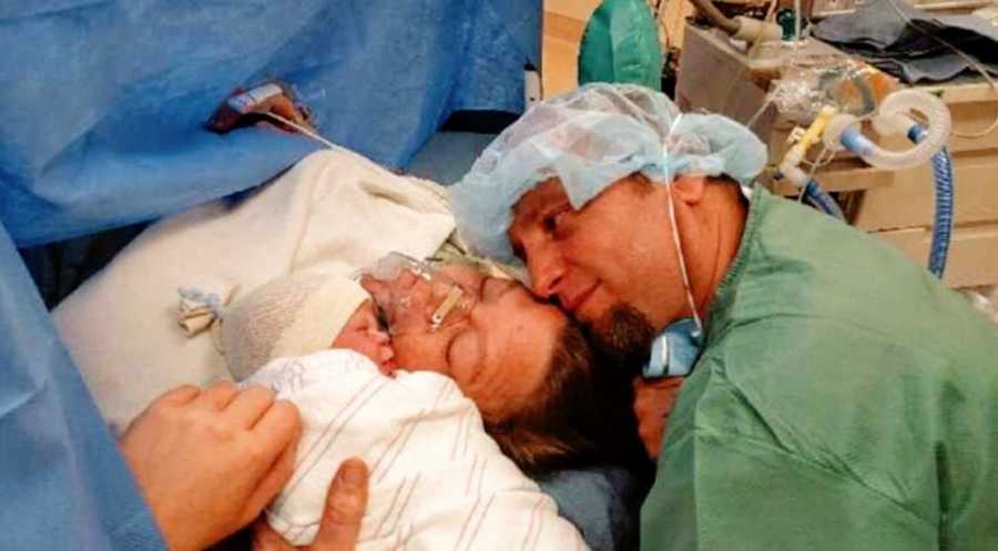 Mom on operating table and dad in scrubs welcome their newborn baby boy