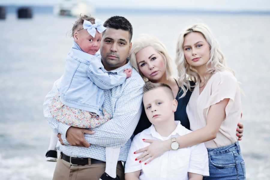 Family pose for a serious photo during photoshoot on beach