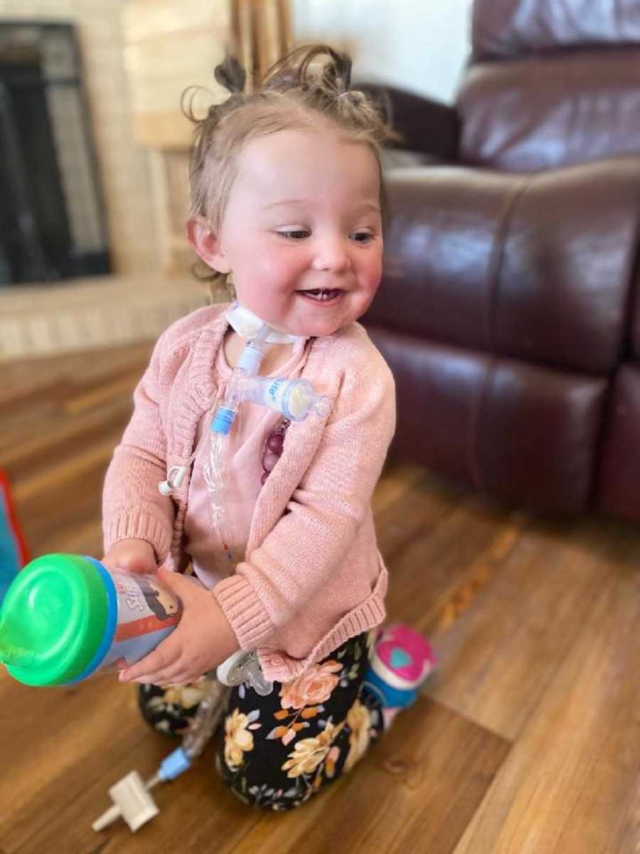 Baby with tracheostomy smiling and playing