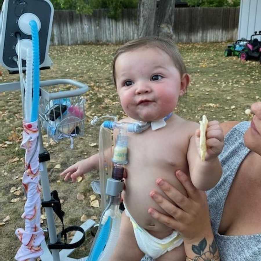 Baby with tracheostomy smiling with mom