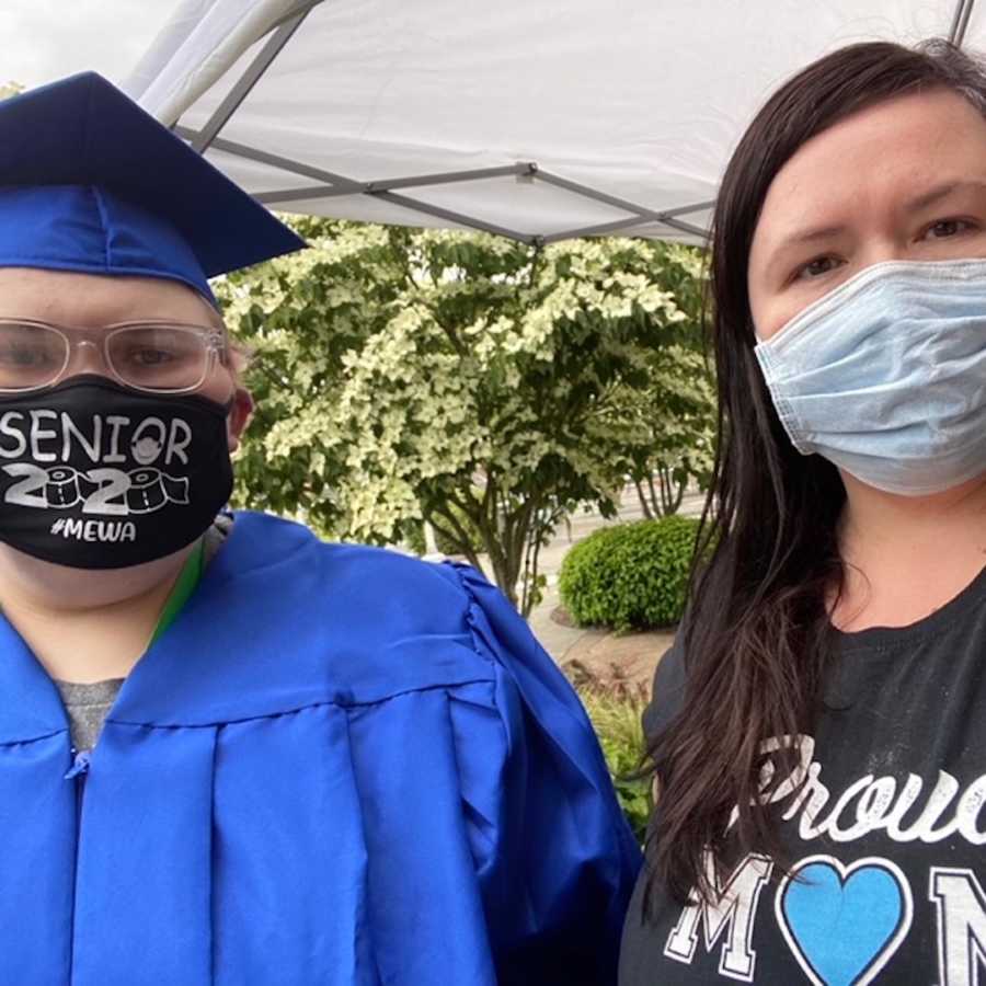 Girl in graduation cap and gown, friend with her