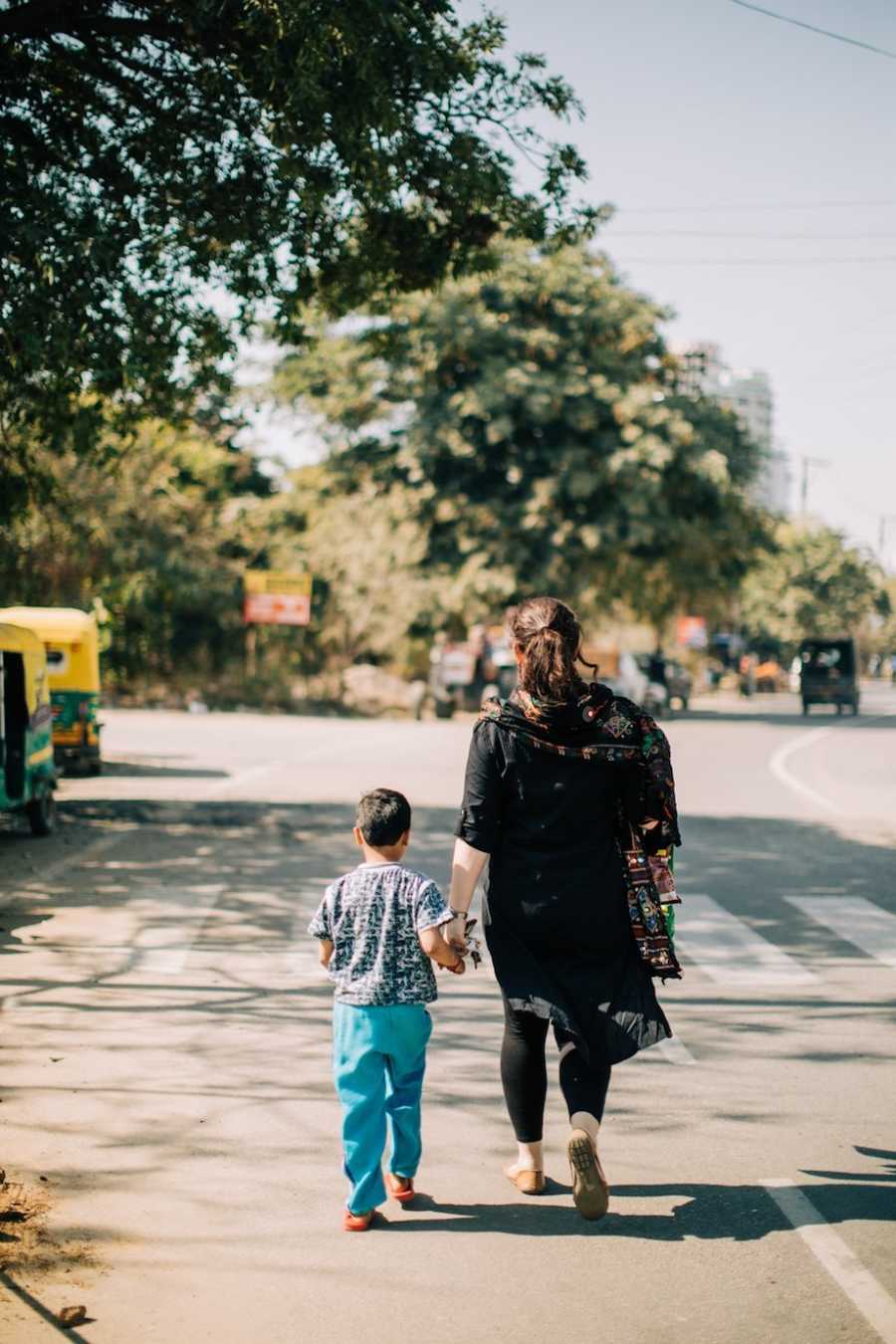 Mother holding adopted child's hand