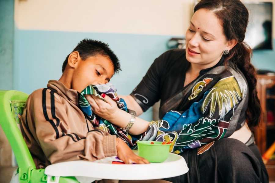 Mom feeding special needs child