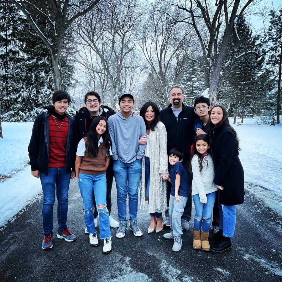 Woman who has battled mental illness her whole life poses with her husband and eight kids for a family photo