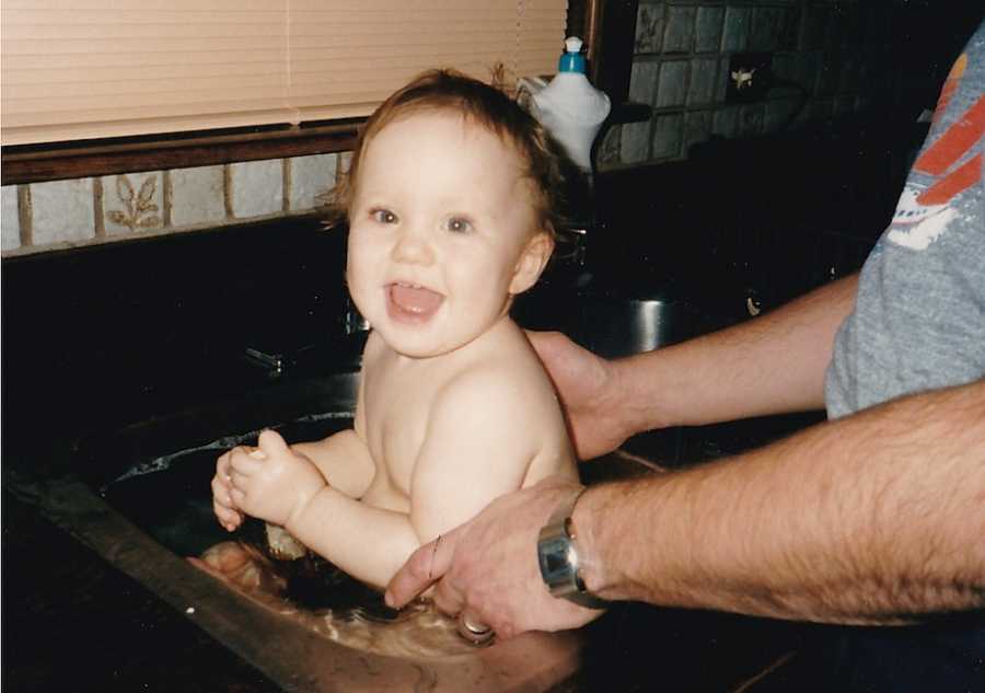 Baby taking bath in sink