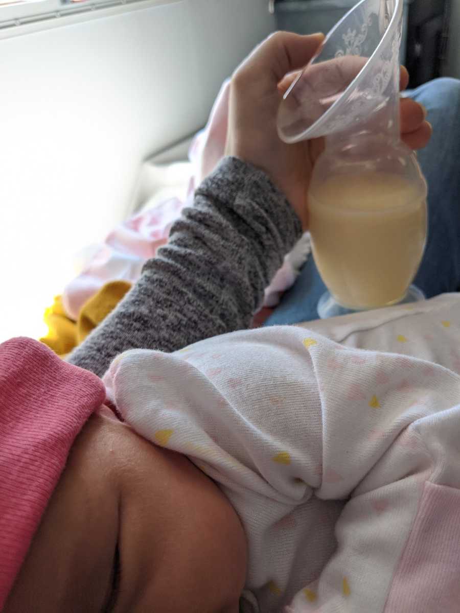 mom holding breastmilk with baby 
