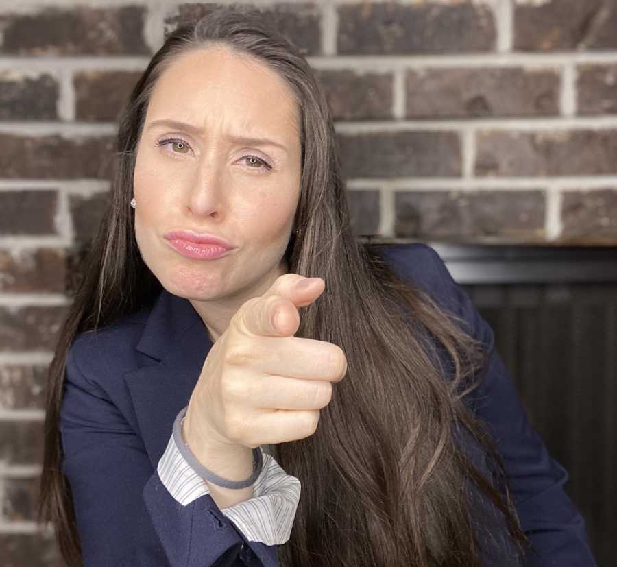 woman in suit pointing at camera