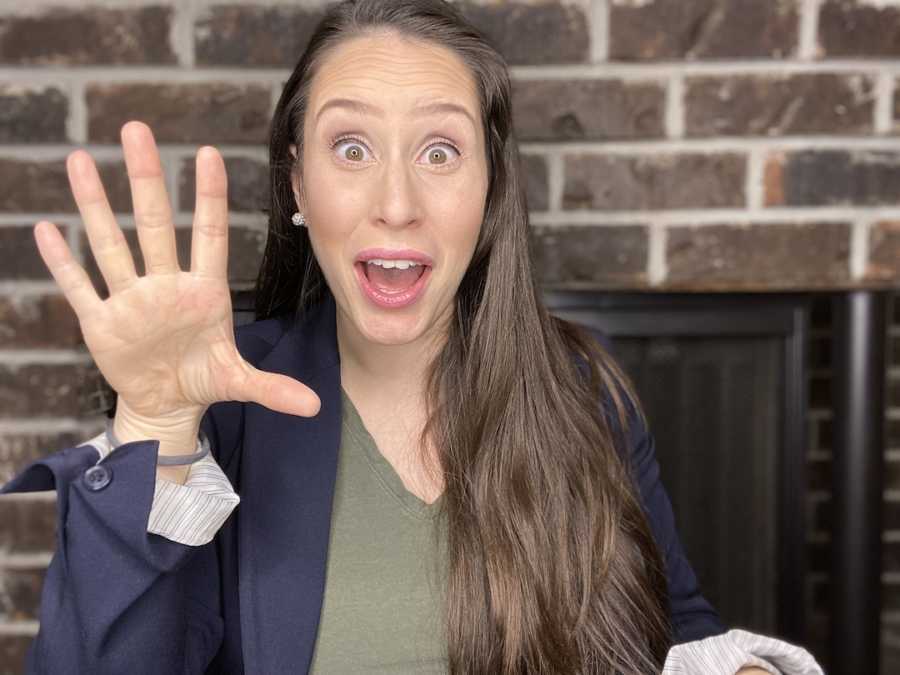 woman holding hand to camera