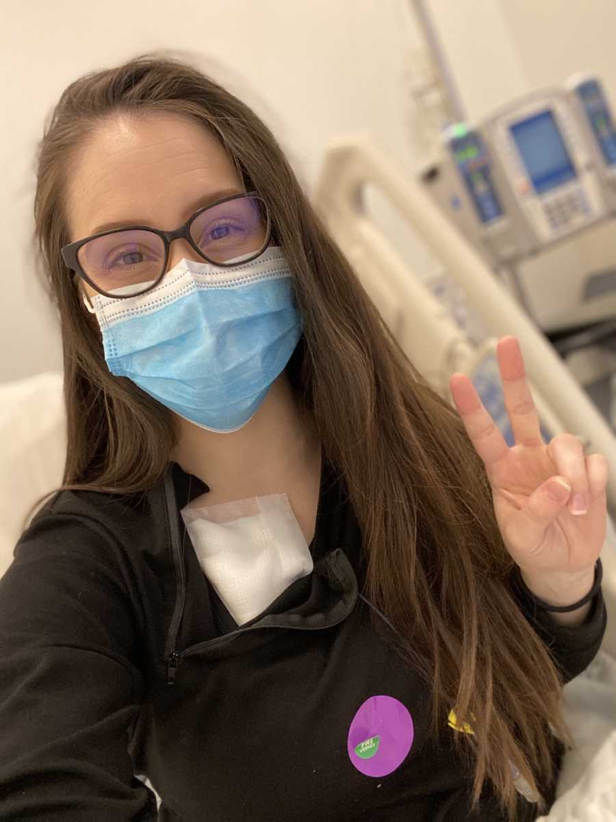 woman in face mask making a peace sign