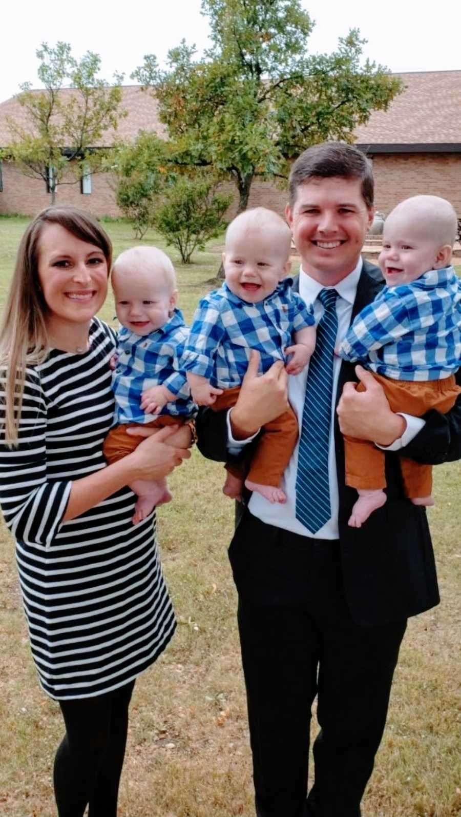 Couple with three identical male triplets pose for a photo at Sunday Church