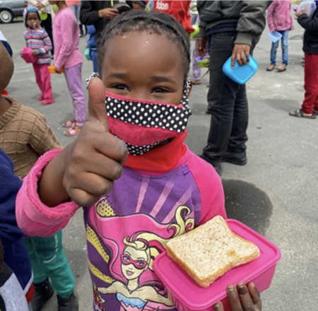 Little girl with mask giving a thumbs up