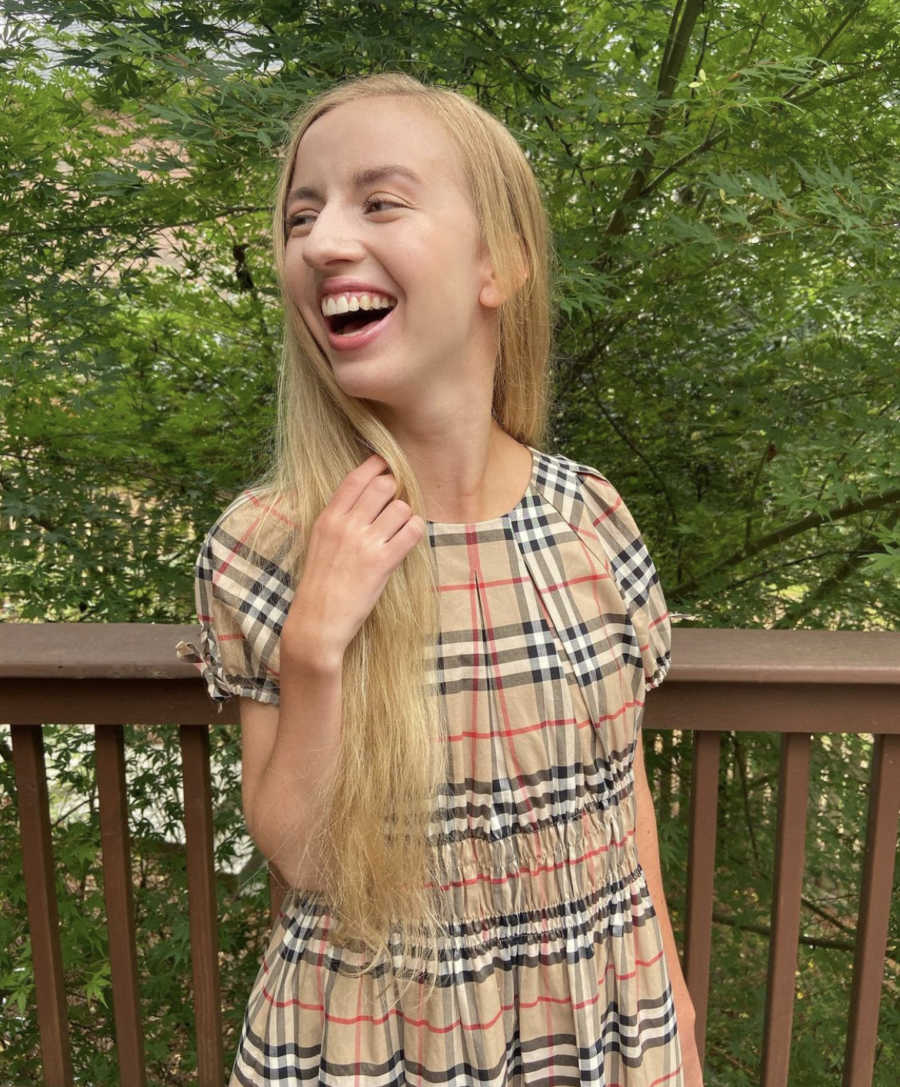 Girl smiling in front of a tree