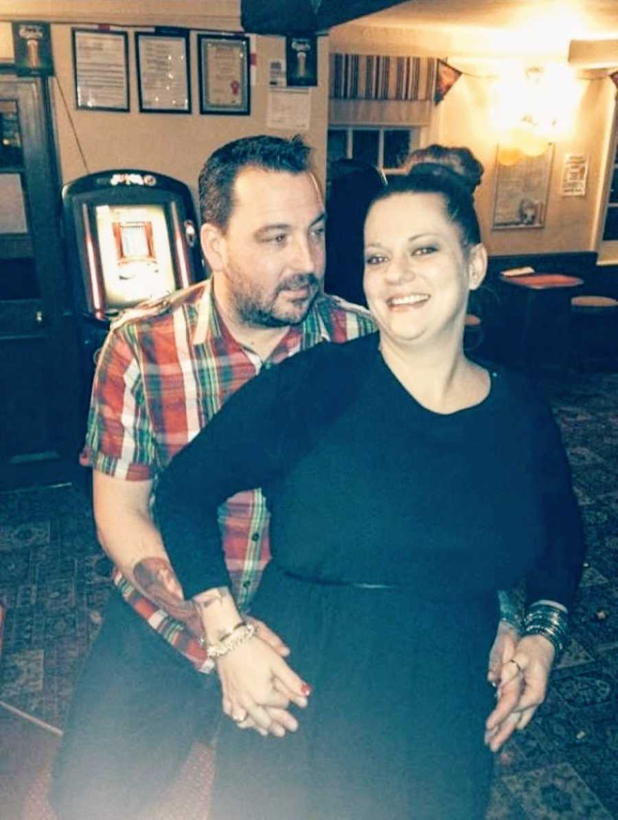 Tattooed couple pose for a photo together in a pub