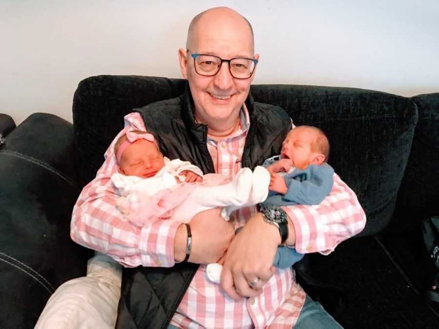 Grandfather proudly holds his newborn grandbabies, surprised by twins