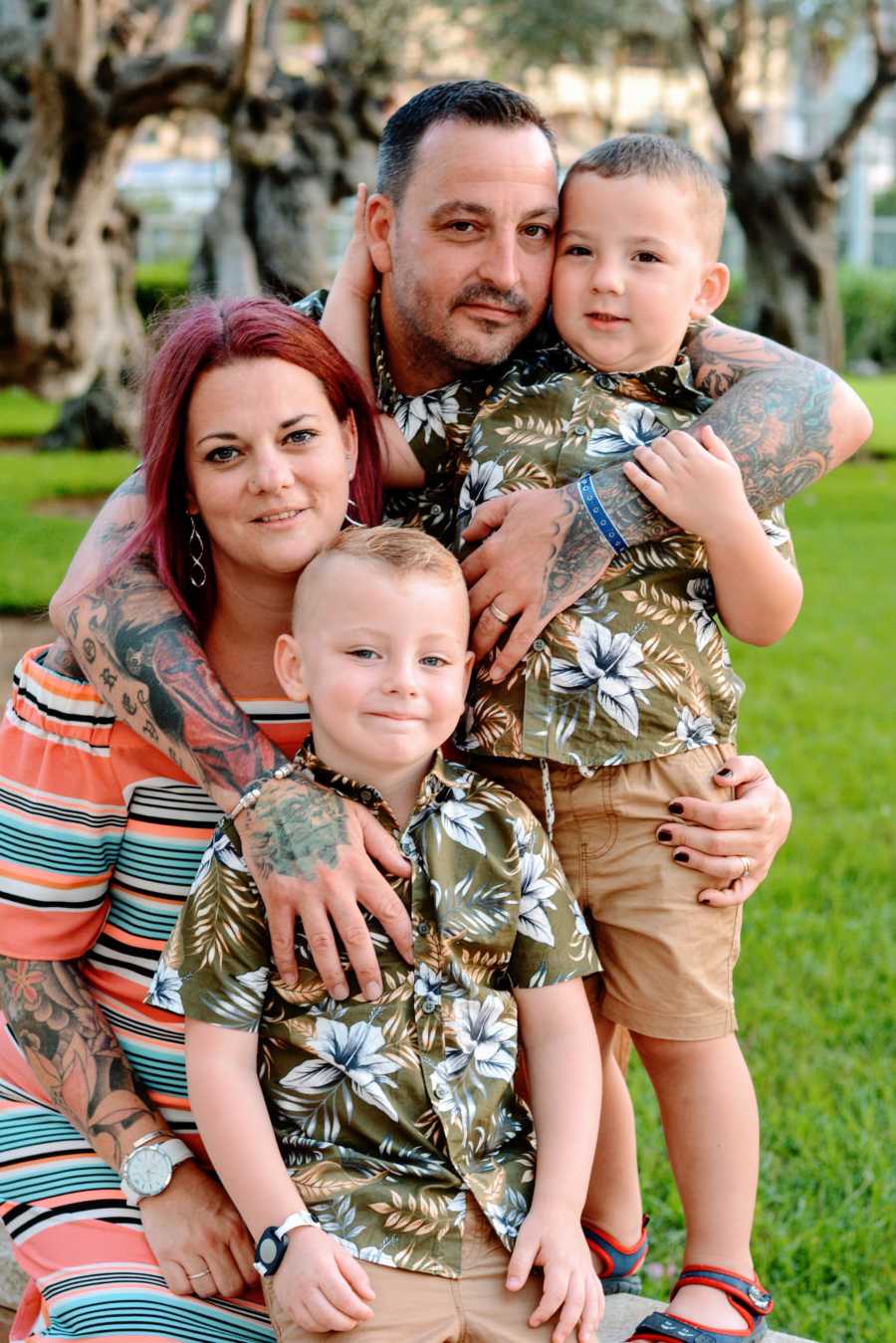 Couple hug two of their sons in tropical photoshoot