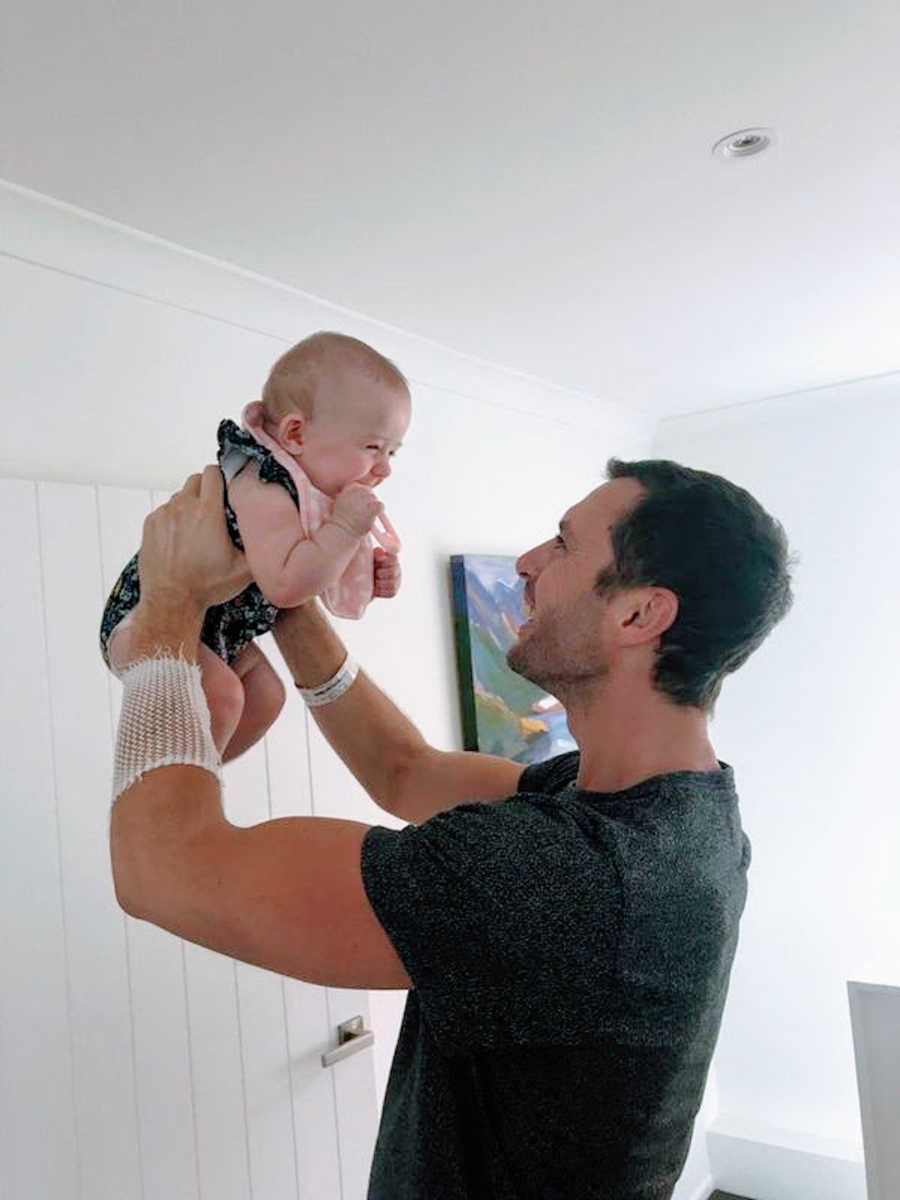 Father holding his smiling baby up in the air