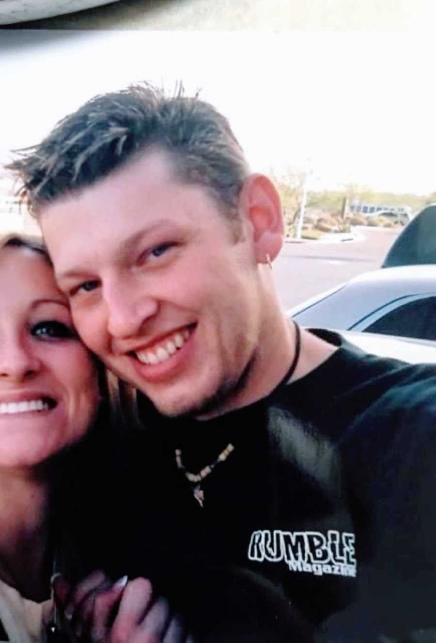 Young man with spikey hair and a goatee takes a selfie with a girl