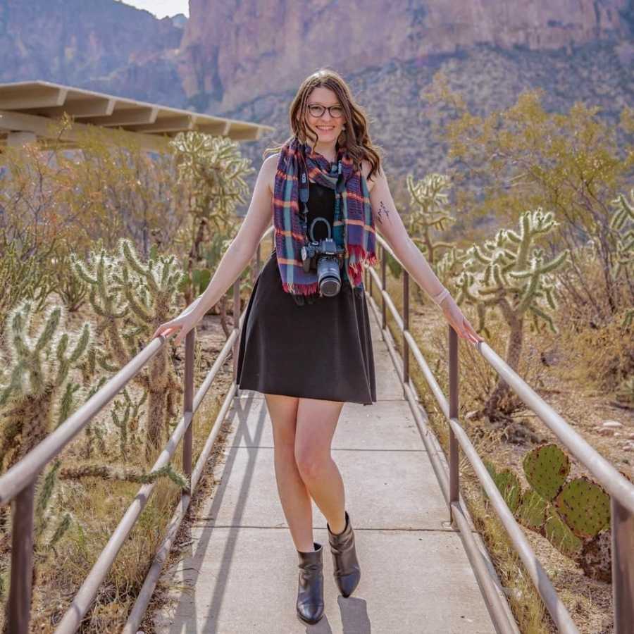 Woman poses for a photo out in the Arizona desert with her camera