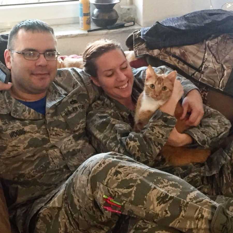 couple in military uniforms holding a cat