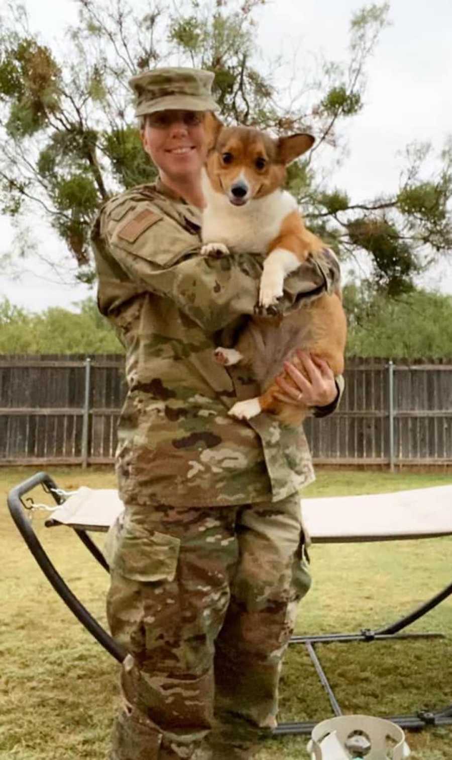 woman in military uniform holding a corgi