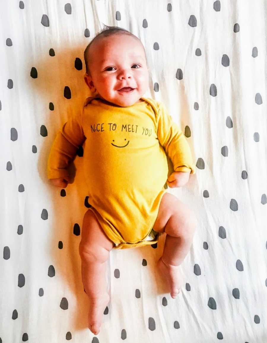 Baby wearing yellow onesie 