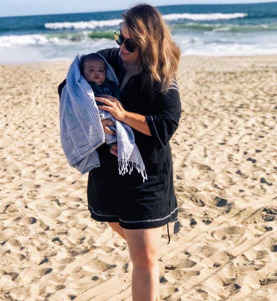 Mother holding baby on the beach