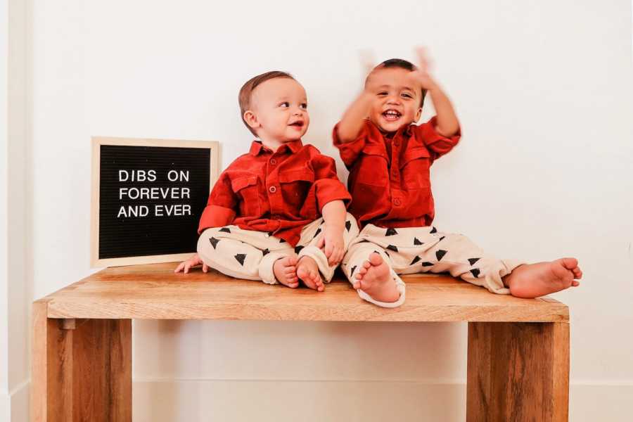 Brothers sitting on table beside a letterboard