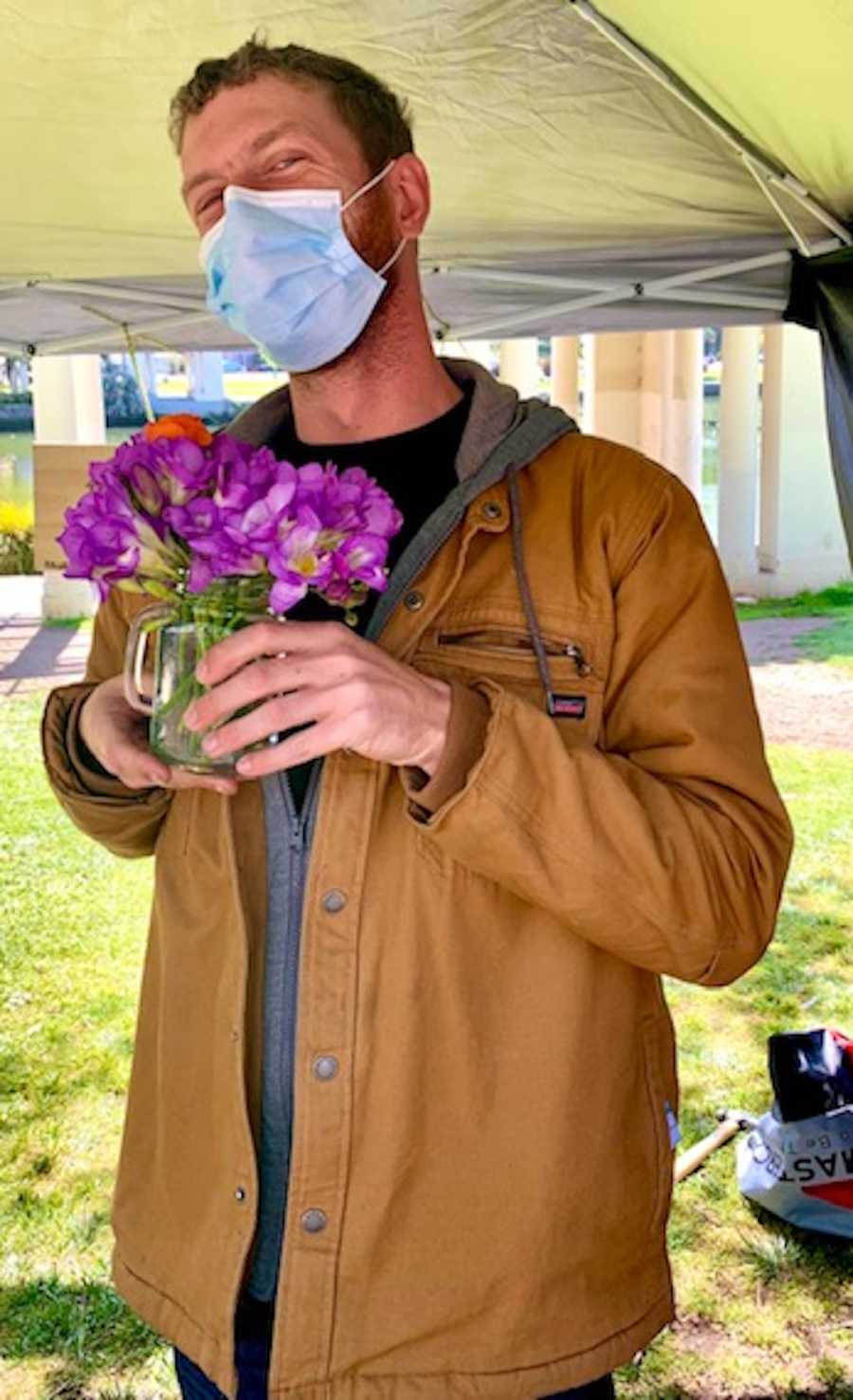 man holding bouquet of flowers