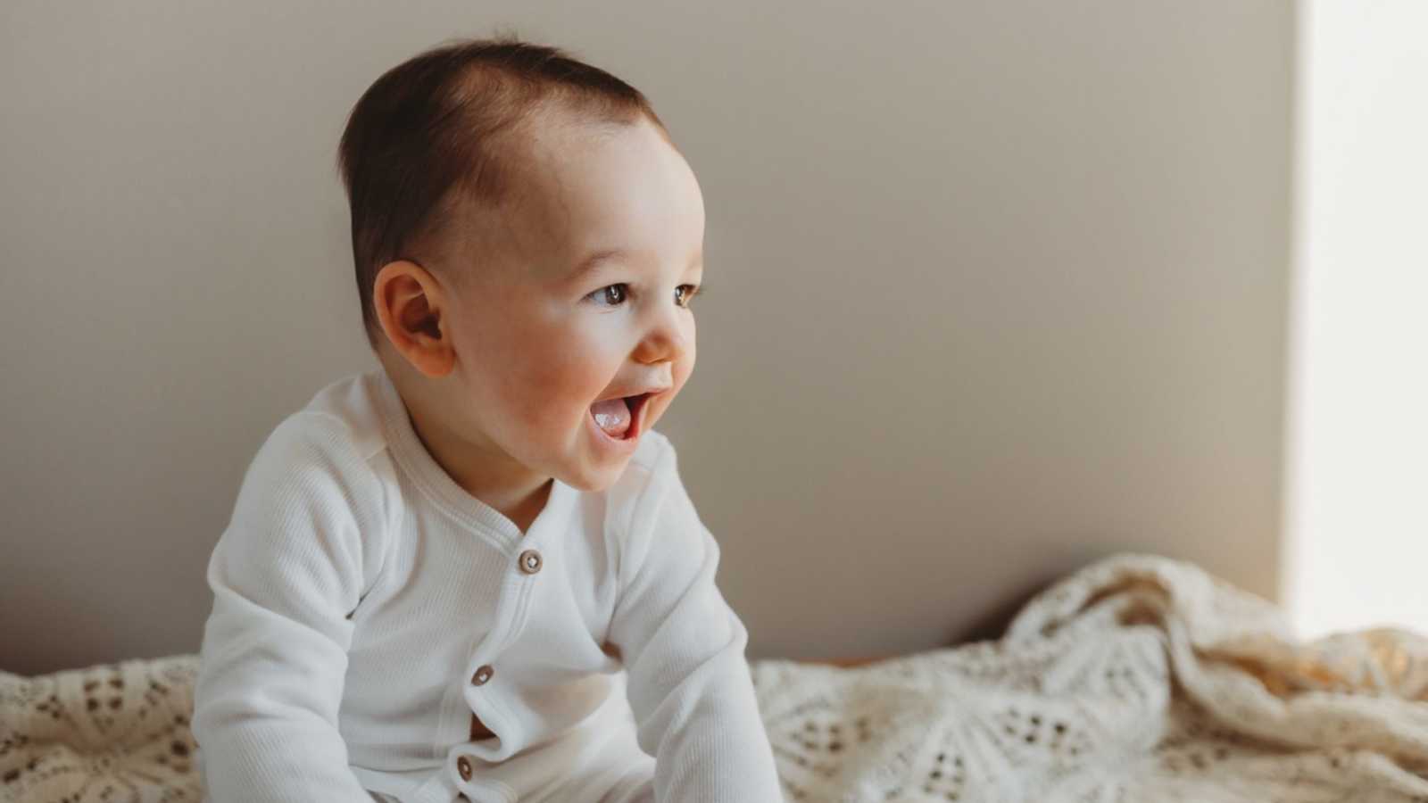 Young toddler gives a big, toothless grin during photoshoot