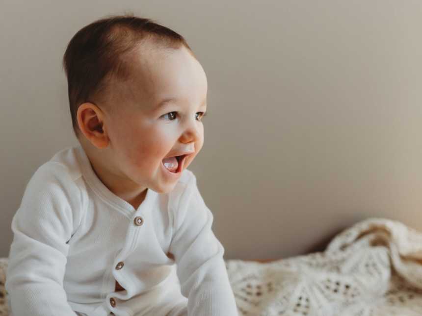Young toddler gives a big, toothless grin during photoshoot