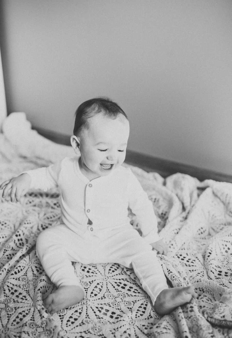 Black-and-white photo of an 18-month baby in a white onesie