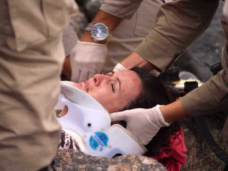 Woman being rescued wearing a neck brace