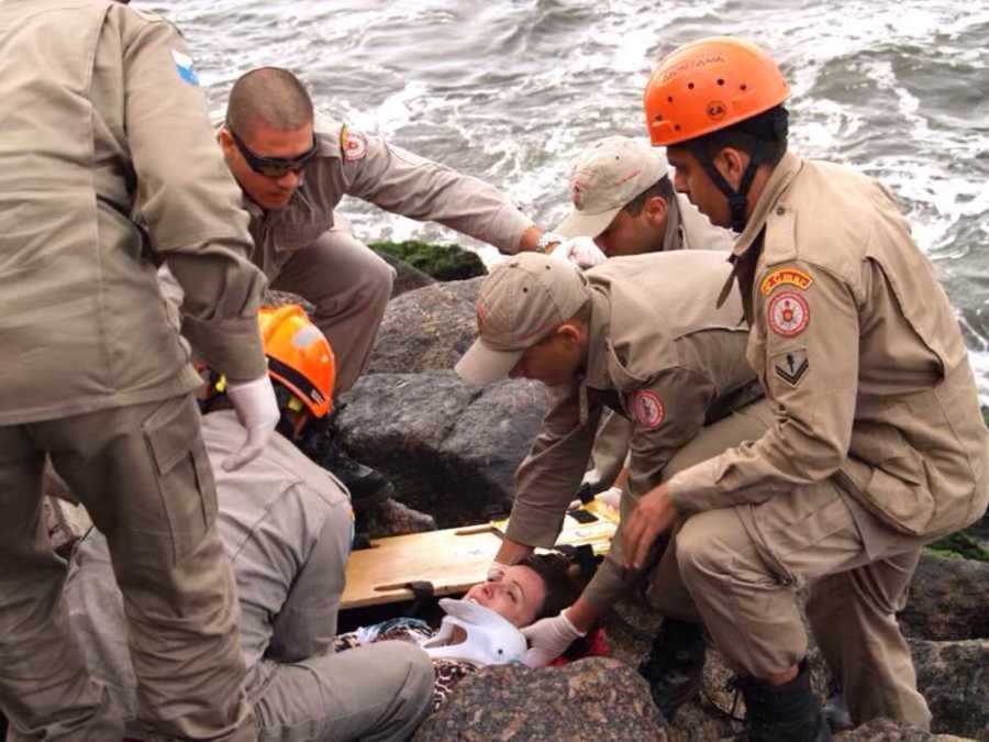 Woman being rescued from rocks