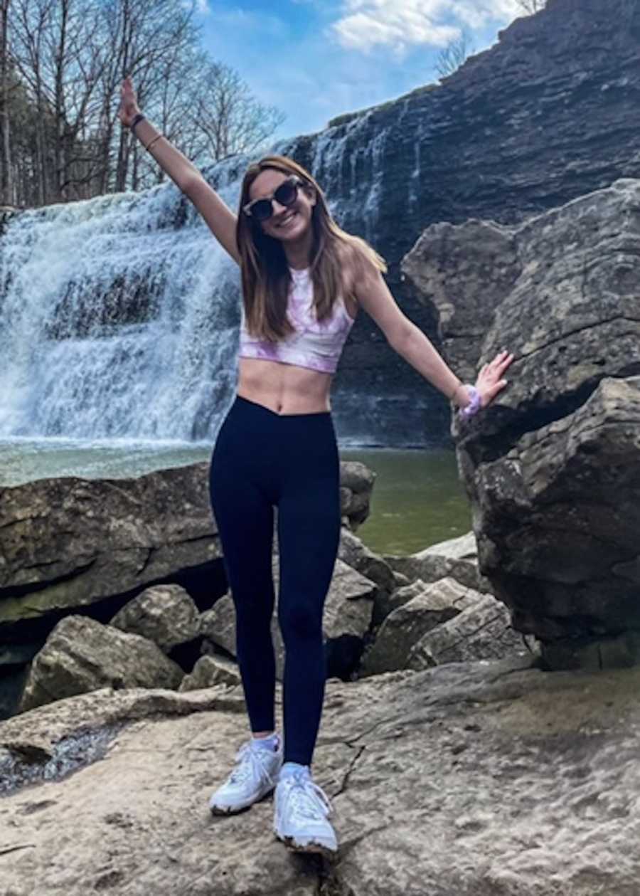 girl standing by waterfall