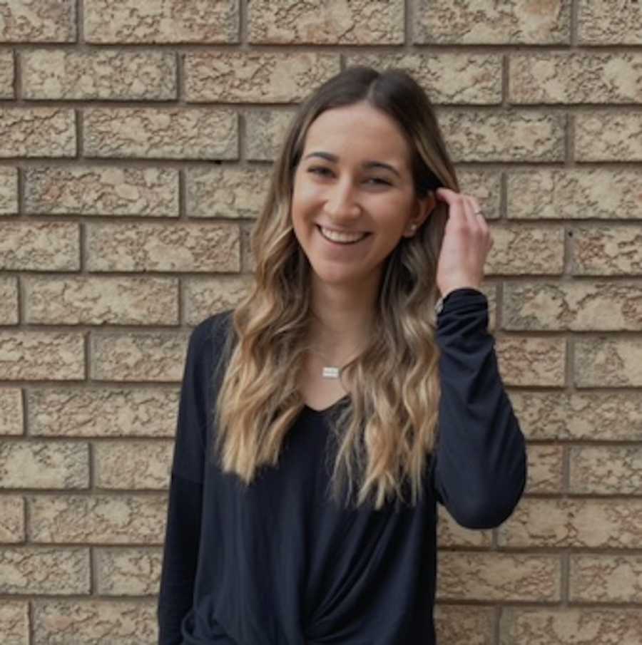 photo of girl by brick wall