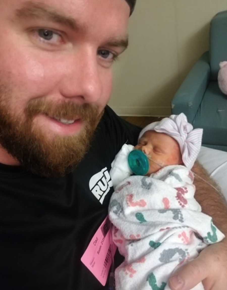 Father holding newborn daughter