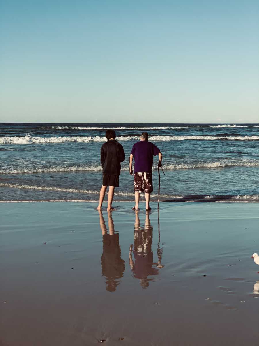 Dying man using cane feels the ocean lap at his feet